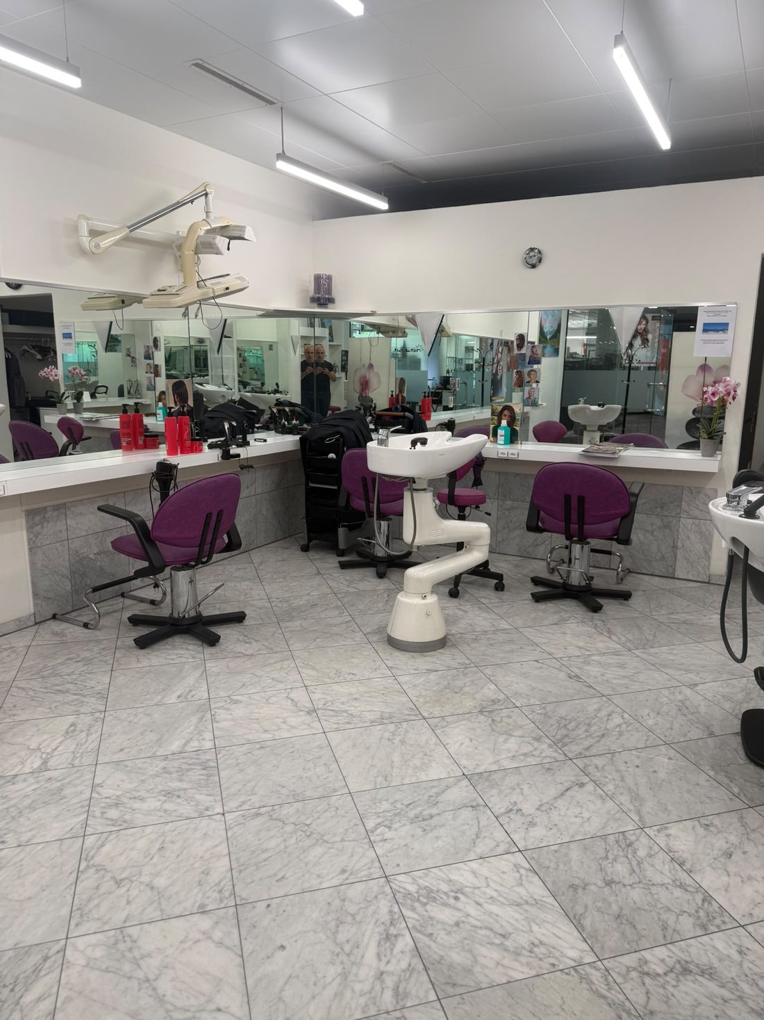 Arbeitsplätze mit Spiegelwand und Waschbecken im Salon New Style